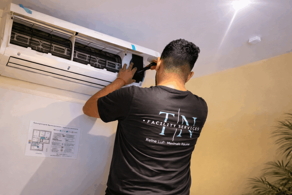 Techniker installiert Split-Klimaanlage an der Wand in Essen